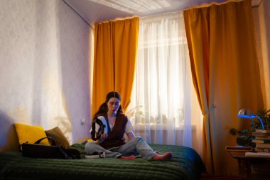 Teknoloji meraklısı kadın yatak odasındaki VR kulaklığı kullanarak artırılmış simülasyondan hoşlanıyor. Yenilikçi ev eğlencesi konsepti. Düşük açı, geniş açı..