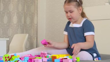 Yaratıcı çocuk yapı ve tasarımı keşfetmek için oyuncak blokları kullanır. Aktif oyun sayesinde anaokulu becerilerini geliştiriyor. Orta çekim.