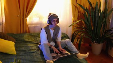 Gözlüklü, şık giyinmiş genç esmer kadın dizüstü bilgisayarda yazı yazıyor, online öğrenim konsepti, uzaktan kumandalı iş ve dijital iş. Geniş açı