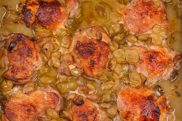 stock image Chicken thighs baked with grape berries in the oven tray, top view close-up