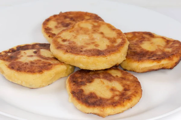 Stock image Freshly fried small thick cheese pancakes on the dish, fragment close-up in selective focus