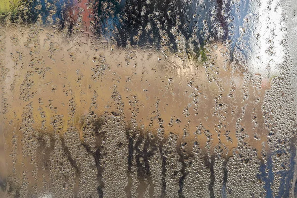 ガラス 質感を介して外部のぼやけた環境へのビュー内のストリームと水の滴で覆われた霧窓のペイン — ストック写真