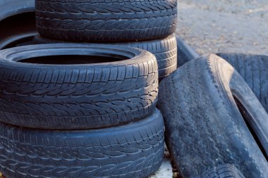 Farklı eski araba ve lastik yığınları, aşınmış lastik izleri, yakın çekim parçaları.