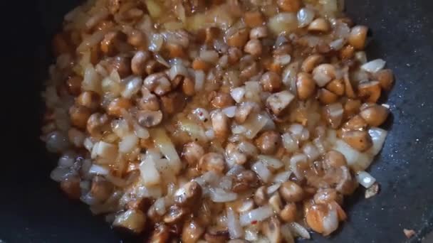 在烹调用油中油炸时带有洋葱的蘑菇 — 图库视频影像