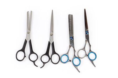 Birkaç çift profesyonel paslanmaz çelik, normal kuaför makas ve saç inceltici makas, beyaz arka planda üst görünüm.