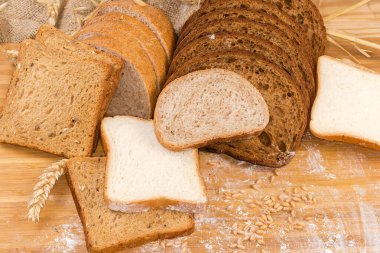 Çavdar ekmeği ve buğday unundan dilimlenmiş koyu kahverengi ekmek kepekli ekmek, kızartılmamış beyaz ekmek ve kulaklar arasında kızarmak için tam tahıl ekmeği ve un ile saçılmış tahıl.