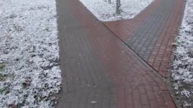 Yaya yolu kenarlarında taze kar olan asfalt levhalarla dolu.