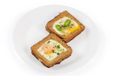 Kızarmış yumurtadan yapılmış iki açık sandviç. Güneşli tarafı yukarıda. Beyaz arka planda, tost için tam buğday ekmeği.