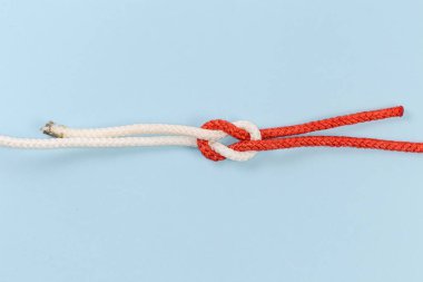 Rope granny knot, also known as false knot on a blue background