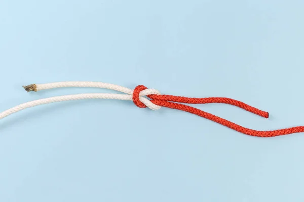 Rope reef knot, also known as square or double knot on a blue background