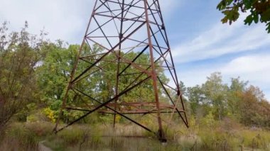 Lattice steel transmission tower of overhead power line in forest