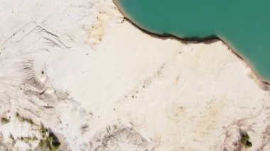 Waste rock dumps, lake in ilmenite quarry, vertical aerial view