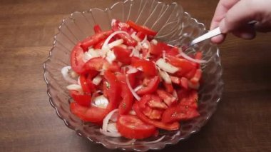 Mixing of ingredients of the vegetable salad of fresh tomatoes