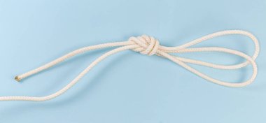 Rope knot as double figure-eight loop, also known as bunny ears or double Flemish loop on a blue background