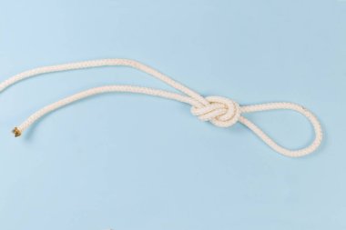 Rope knot as overhand loop, also known as loop knot on a blue background
