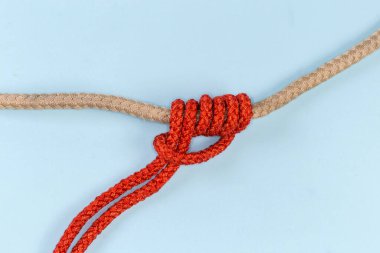 Rope klemheist knot tied with an accessory cord on the main rope on a blue background