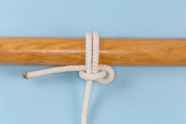 Rope knot Pedigree cow hitch, version of the cow hitch, when only one rope is being pulled. Used to attach a rope to an object, view on a blue background