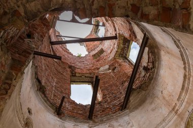 Scenic ruins of the part of the old palace with tower, inside view the partially destroyed tower against the cloudy sky