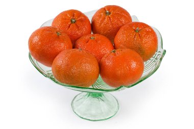Whole ripe tangerines Murcott, also known as honey tangerines in the vintage green glass vase for fruits on a white background