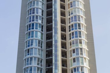Fragment of the facade of the modern multistory building on a background of a clear sky