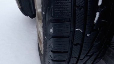 Part of car wheel and tire tracks on a snow