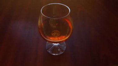 Brandy in cognac glass after shaking on the wooden table