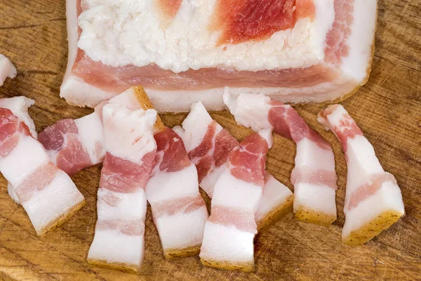 板の上に肉の層を持つ皮膚上の塩豚の脂肪の部分に対する小さなスライス 断片のクローズアップ — ストック写真