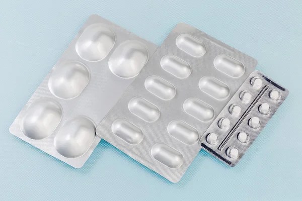 薬の丸薬と全体ブリスターパックブルー面上の異なるサイズ — ストック写真