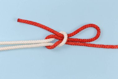 Halat Singly kaygan resif düğümü, bir ucu mavi bir zemin üzerinde bir döngü ile kayma formu olarak kaydırak