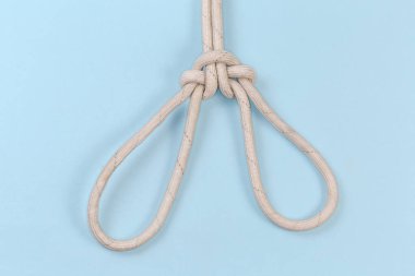 Halat düğümü İspanyol bovling ipi, bir insanı kaldırmayı amaçlıyor, mavi arka planda görünüm