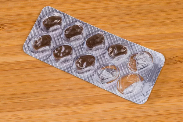 Embalagem Blister Iniciada Com Cápsulas Marrons Medicação Superfície Madeira — Fotografia de Stock