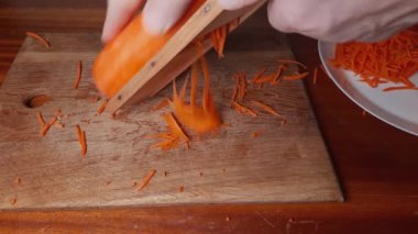 Öğütücüyle ince ince dilimler halinde havuç doğrarken.