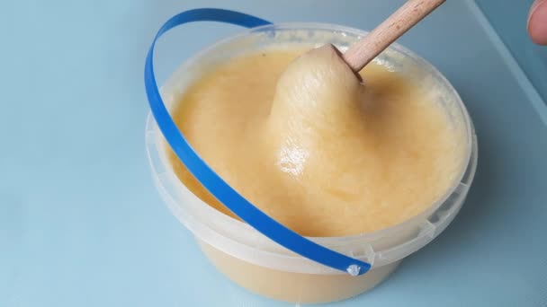 Dicker Honig Wird Mit Honiglöffel Aus Plastikbehälter Geholt — Stockvideo