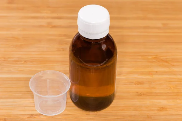 Geschlossene Kleine Braune Glasflasche Mit Flüssigen Medikamenten Und Messbecher Aus — Stockfoto
