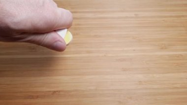 Tüpten çıkan coşkulu hapları ahşap yüzeye dökerek.