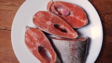 Kırsal masadaki beyaz tabakta pişmemiş gökkuşağı alabalığı parçaları