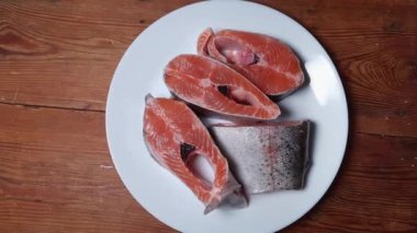 Kırsal masadaki beyaz tabakta pişmemiş gökkuşağı alabalığı parçaları
