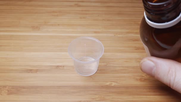 Flüssiges Medikament Aus Der Glasflasche Den Messbecher Gießen — Stockvideo