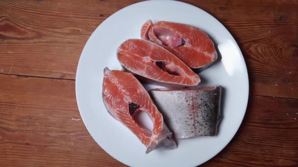 未煮熟的彩虹鳟鱼片放在乡村餐桌上的白盘上 — 图库视频影像