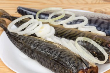 Sıcak tütsülenmiş, soğuk dumanlı ve tuzlu Atlantik uskumrusu. Kafaları çiğ soğan halkalarıyla süslenmiş.