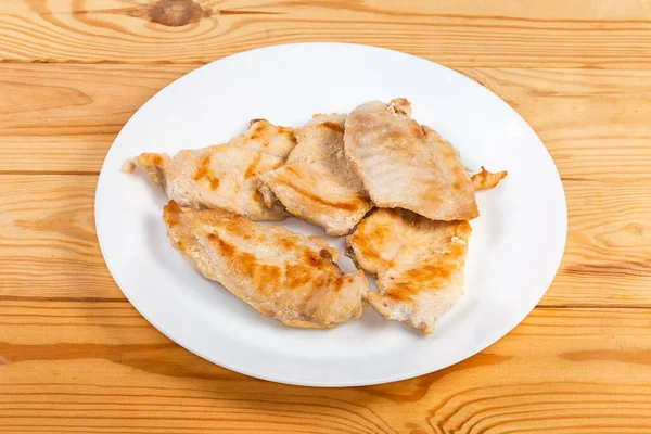 Düz Dilimlenmiş Tavuk Göğsünü Kırsal Masada Beyaz Bir Tabakta Kes — Stok fotoğraf