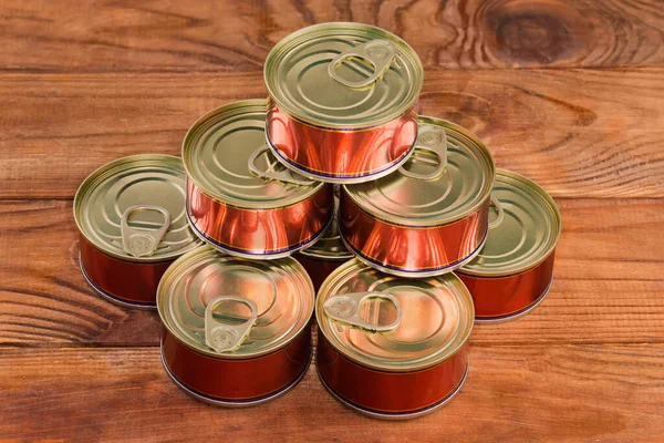 素朴なテーブルの上に簡単に開いた蓋を持つ缶詰の魚の小さな丸い密封された錫缶のヒープ — ストック写真