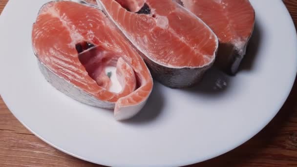 未煮熟的彩虹鳟鱼片放在乡村餐桌上的白盘上 — 图库视频影像