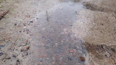 Yağmur sırasında beton ve çakıl yüzeyinde yağmur suyu birikintisi