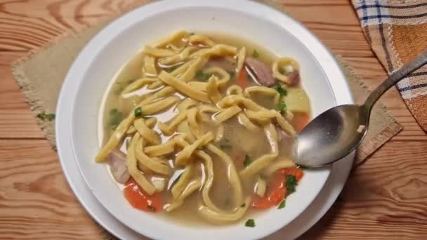 ホワイトボウルにスプーンで熱々のチキンヌードルスープの攪拌 — ストック動画