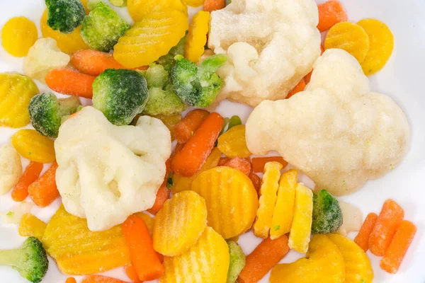 将切碎的冰冻菜花 花椰菜和白盘上覆盖着成熟的两种胡萝卜混合在一起 成片地进行特写 — 图库照片
