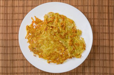 Bambu restoranının paspasında, beyaz tabakta taze kızarmış patates krepleri.