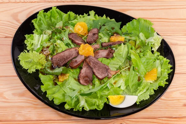 Salade Gemaakt Van Gekookt Eendenvlees Sinaasappelschijfjes Verschillende Greens Zwarte Schotel — Stockfoto