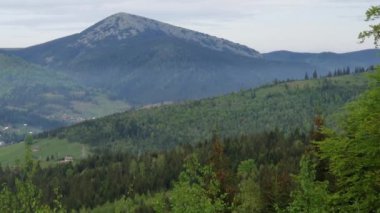 Karpat Dağları 'ndaki vadideki dağ köyü bulutlu bir akşamda