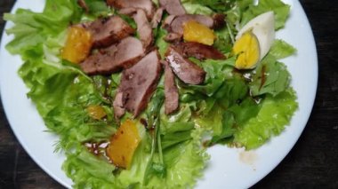 Haşlanmış ördek etli salata, yumurta, portakal ve farklı yeşillikler.